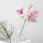 A vase filled with pink flowers on top of a table