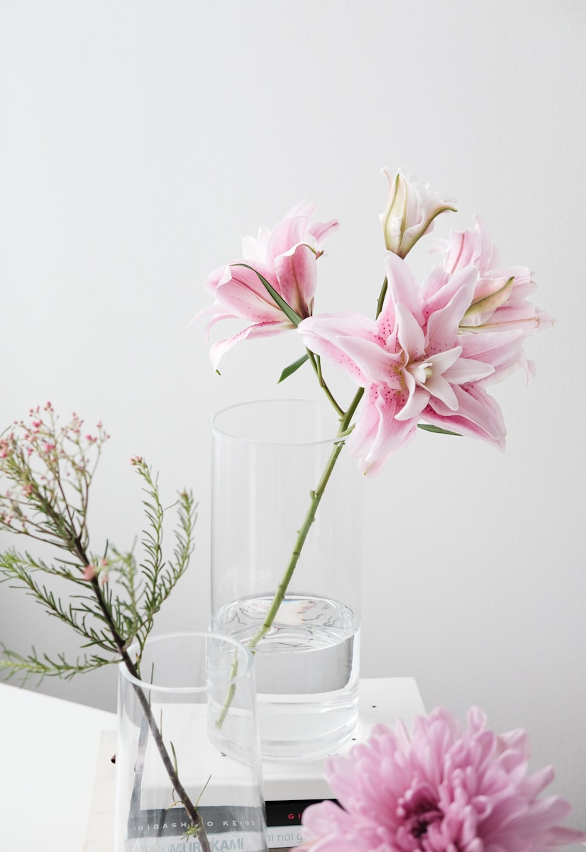 A vase filled with pink flowers on top of a table