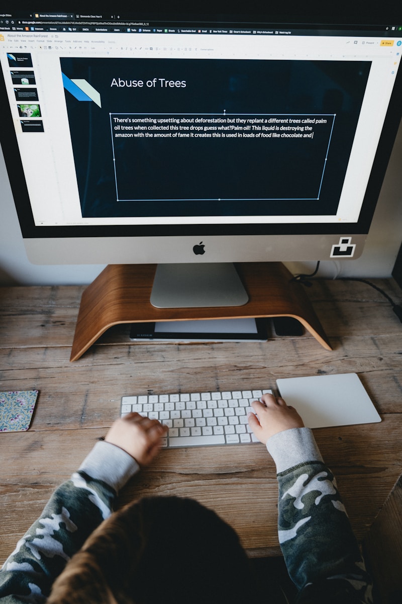 person in gray long sleeve shirt using silver imac